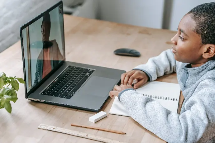 Un enfant suit son cours SUCCEED en visio sur son ordinateur