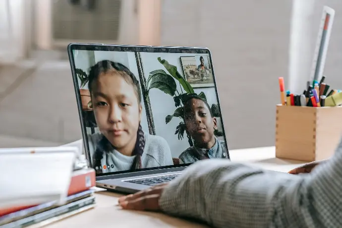 Deux enfants échangent en visio pendant une activité de lecture