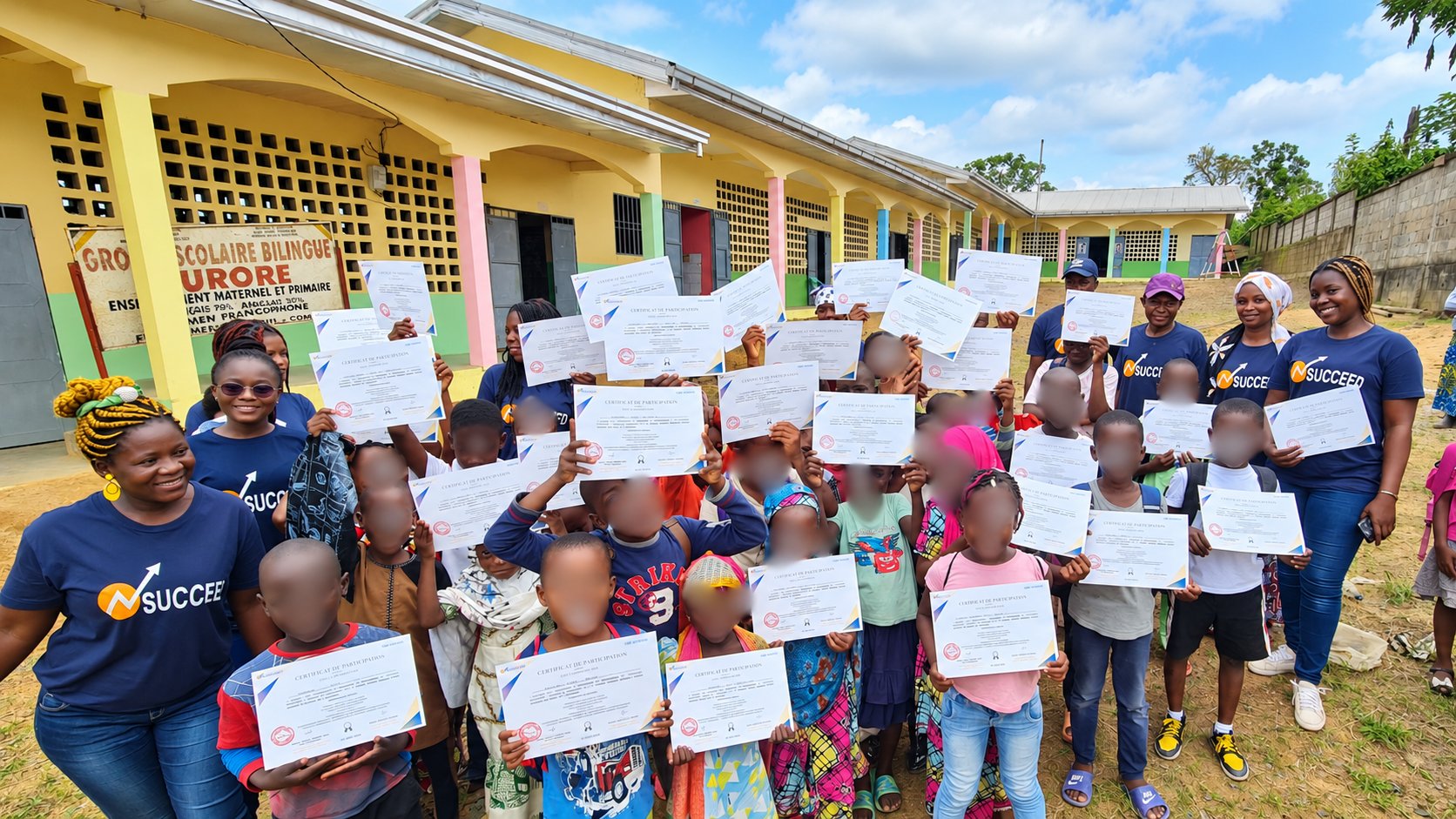 L'équipe SUCCEED et les enfants d'une école, certificats en main